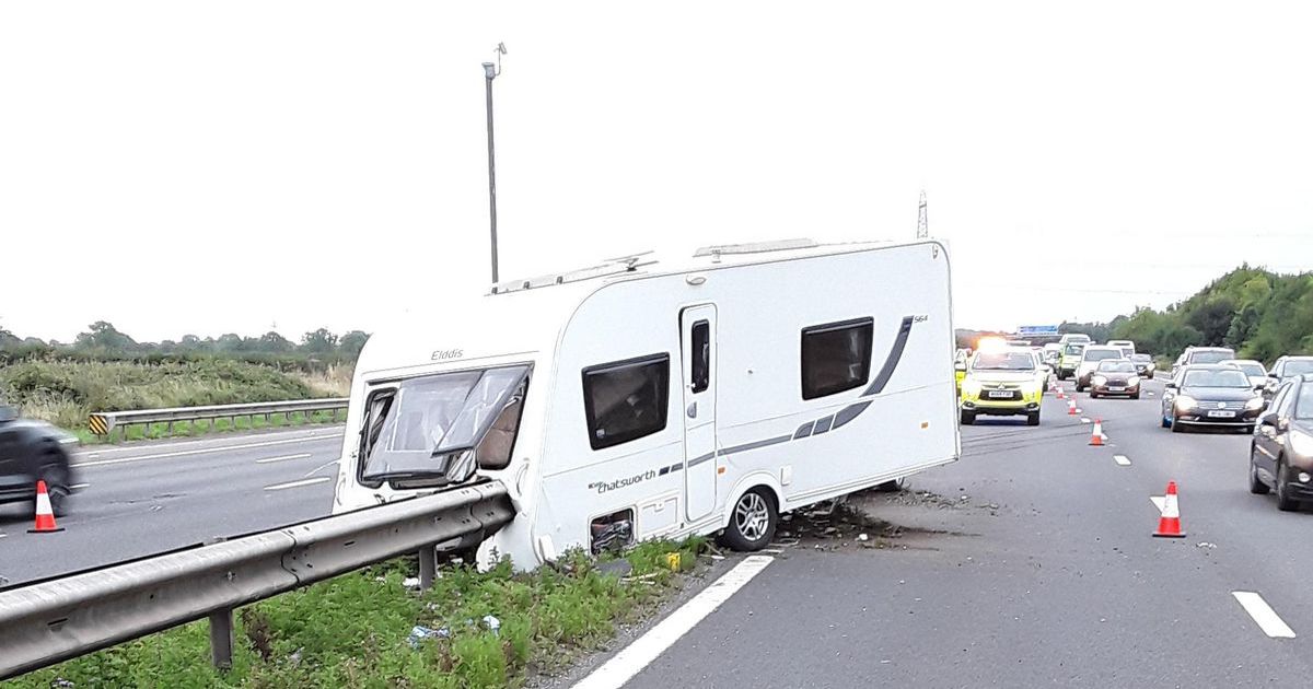 A caravan that has struck the central barrier on a motorway with police and cones in place &mdash; a caravan recovery callout