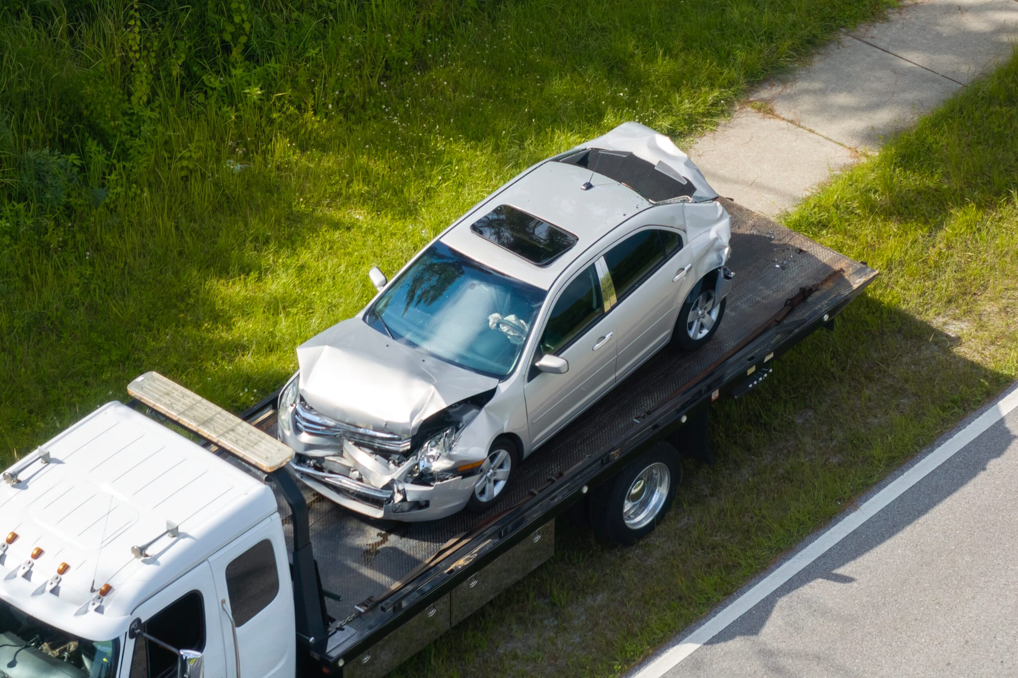Damaged car being loaded onto a recovery truck flatbed