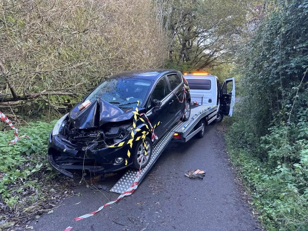 Damaged car loaded onto a recovery flatbed at the roadside