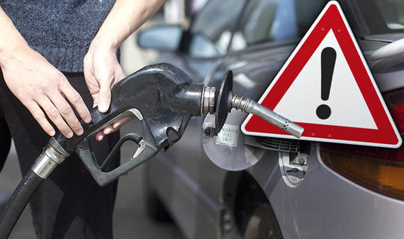 Petrol pump nozzle beside a warning triangle highlighting wrong-fuel risk