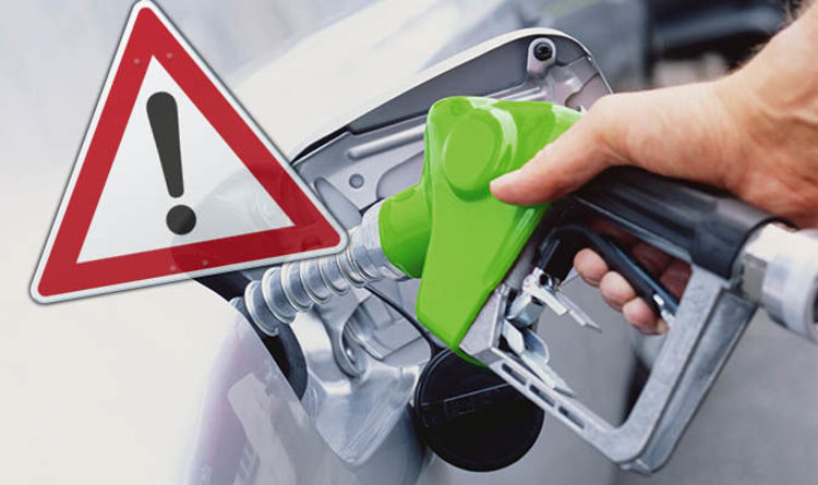 Petrol pump nozzle beside a warning triangle, illustrating the risk of putting the wrong fuel in a car