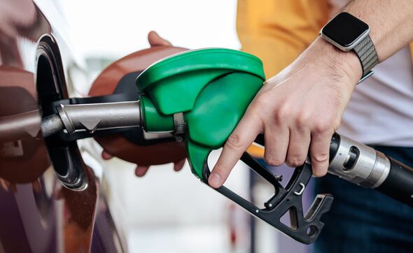 Driver refuelling a car with a petrol pump nozzle