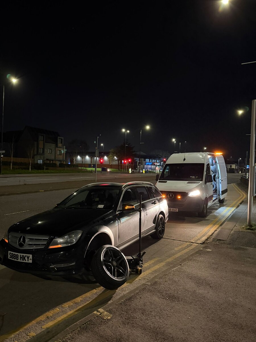 Black Mercedes C-Class being prepared for a night tow under streetlights with a white Mercedes Sprinter recovery van behind, on the way back from Birkenhead.