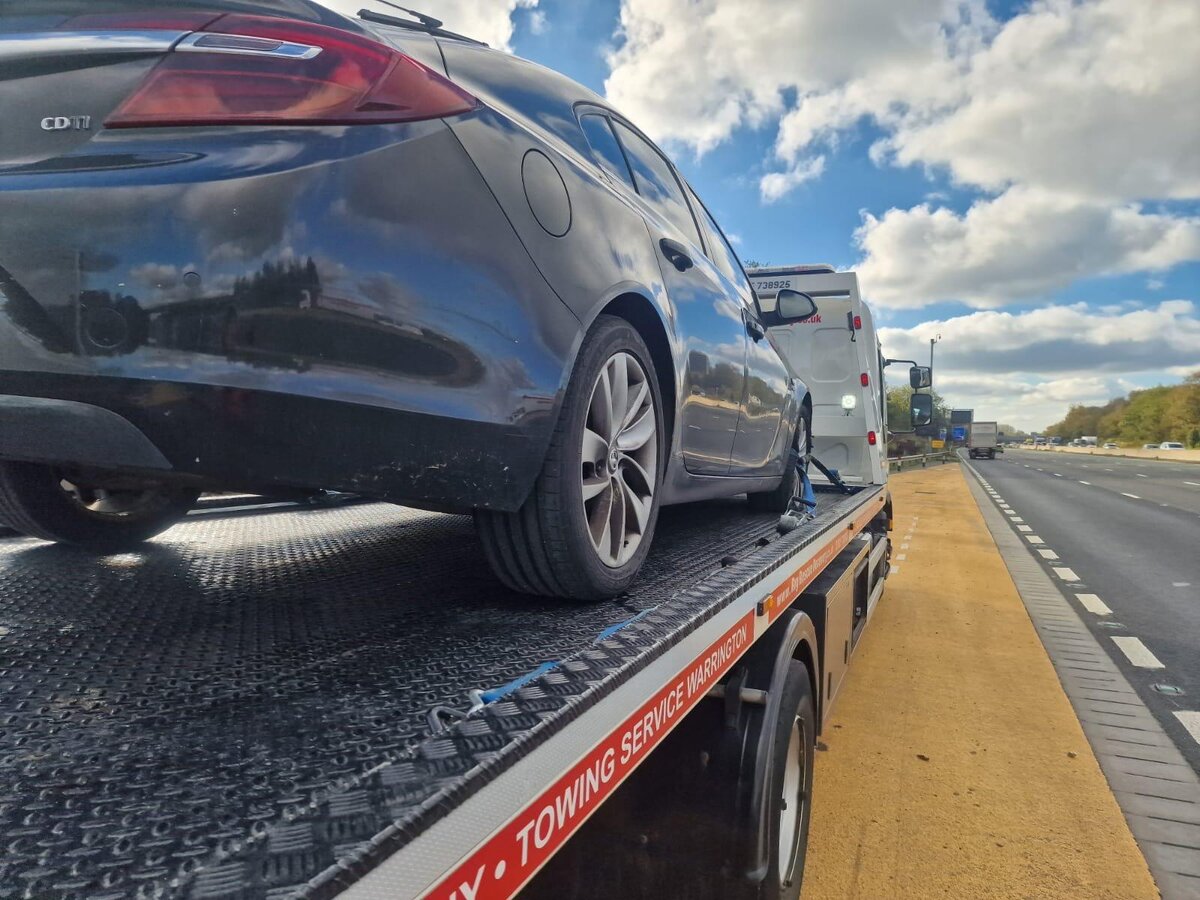 Black Vauxhall Insignia loaded on Breakdown Man's flatbed on the motorway — towing service from Warrington across the North West.