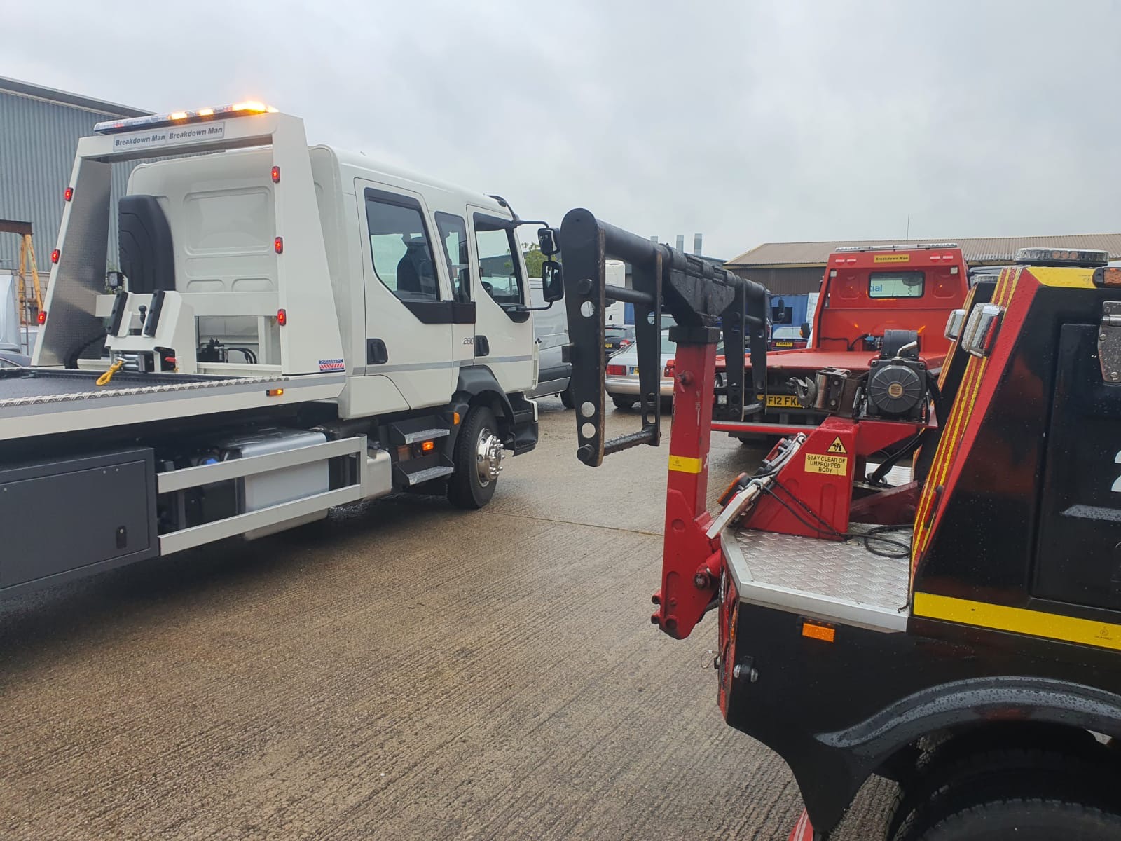 Breakdown Man branded flatbed recovery truck in the depot yard alongside a second recovery truck, ready to dispatch to the M6 corridor.