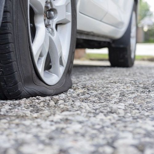 A deflated car tyre at the roadside kerb