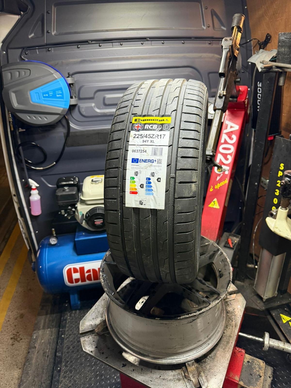 A new tyre fitted to an alloy rim on the workshop machine — the TPMS valve sits inside the wheel.